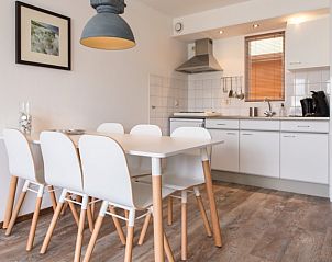 Eetruimte in Wad appartement, Hollum, Ameland met moderne keuken en stijlvolle eettafel, perfect voor vakantiediners.