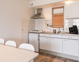 Compacte keuken van Wad appartement in Hollum, Ameland met moderne apparatuur en strakke inrichting.