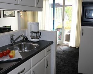 Moderne keuken in Appartment Amelander Kaap, Hollum, Ameland met veel lichtinval en uitzicht op de tuin.