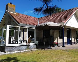 Luchtfoto van De Vrijheid, een vakantiehuis in Hollum, Ameland, omgeven door groene natuur en nabijgelegen duinen op de Waddeneilanden.