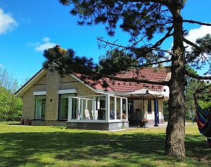 Gezellige woonkamer van vakantiehuis De Vrijheid in Hollum, Ameland, met moderne inrichting en uitzicht op de groene omgeving.