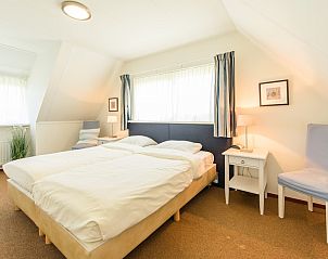 Comfortabele slaapkamer in Beachvilla West End 6, een bungalow in Hollum, Ameland, met zachte bedden en natuurlijk licht.