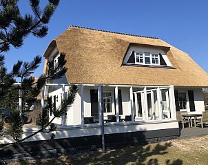 Engelsmanduinvilla 6, een charmante bungalow in Hollum, Ameland, met rieten dak en zonnig terras, omgeven door natuur op de Waddeneilanden.