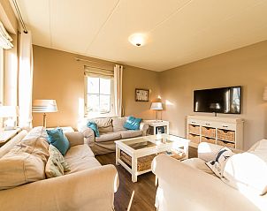 Gezellige woonkamer in Engelsmanduinvilla 6, een vakantiehuis in Hollum, Ameland, met comfortabele banken en veel natuurlijk licht.