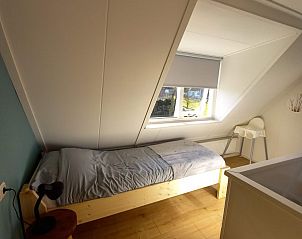 Gemtlicher Schlafbereich im Ferienhaus Flipper Hollum Ameland mit Blick auf den Garten.