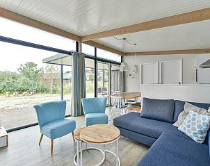 Lichte woonkamer in Vrijstaande woning in Hollum, Ameland met uitzicht op de omgeving.