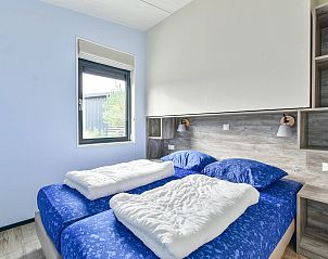 Comfortabele slaapkamer in Vrijstaande woning in Hollum, Ameland, met uitzicht op de tuin.