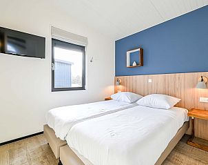 Slaapkamer in vrijstaande woning in Hollum, Ameland met tweepersoonsbed en tv.