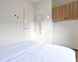 Moderne slaapkamer in vakantiehuis in Hollum, Ameland met houten kast.