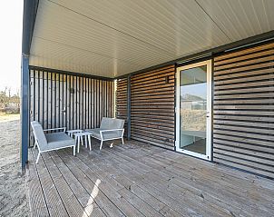 Overdekte veranda met zitgelegenheid in vakantiehuis in Hollum, Ameland.