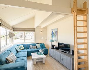 Gezellige woonkamer in Eilandlodge 4, een vakantiehuis in Hollum, Ameland, met comfortabele zithoek en moderne inrichting.
