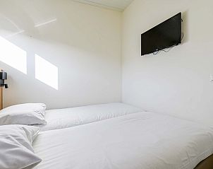 Lichte slaapkamer met tv in de vrijstaande woning in Hollum, Ameland, vakantiehuis op de Waddeneilanden.