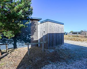 Hoek van de vrijstaande woning in Hollum, Ameland, vakantiehuis omgeven door groen op de Waddeneilanden.
