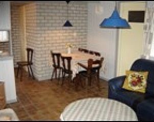 Gezellige eetruimte in vakantiehuis Pirolie, Hollum, Ameland, met landelijke sfeer en comfortabele stoelen.