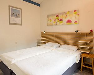Gezellige slaapkamer in Duinvilla 6, een vakantiehuis in Hollum, Ameland. Comfortabele bedden en moderne inrichting op de Waddeneilanden.