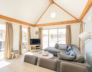 Gezellige woonkamer van Waddenlodge 6 in Hollum, Ameland met ruime zitbank, grote ramen en veel natuurlijk licht.