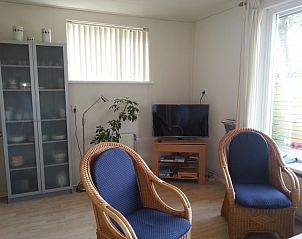 Zithoek in ALFIT vakantiehuis, Hollum, Ameland met rieten stoelen en televisie.