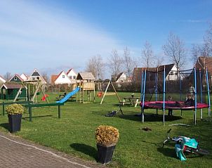 Speelterrein bij Freyenburgh in Hollum, Ameland, perfect voor gezinnen, met glijbanen en trampoline in een groene omgeving.