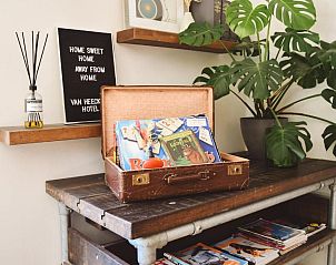 Vintage decoratie in Van Heeckeren Hotel Nes, Ameland, met koffers en boeken.