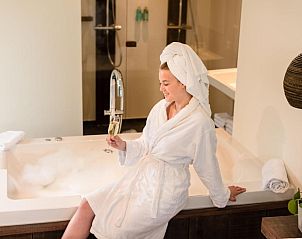 Ontspanning in jacuzzi in Van Heeckeren Hotel Nes, Ameland, met een glas champagne.