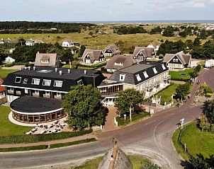 Luchtfoto van Hotel Nes, vakantieappartement in Nes, Ameland, met omliggende natuur en charmante huisjes.