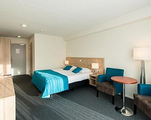 Ruime slaapkamer in Hotel Nes, Nes, Ameland, met comfortabel bed en zithoek.