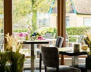 Gezellige eetruimte in Hotel Nes, Nes, Ameland, met bloemen en uitzicht op het terras.