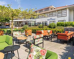 Buitenterras van Hotel Ameland, Nes, met kleurrijke zitplaatsen.