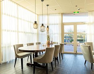 Eetruimte in Hotel Ameland, Nes, met grote tafel en sfeervolle verlichting.