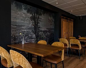 Gezellige eetkamer in Hotel Hofker Nes Ameland met kunst aan de muur.