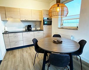 Volledig uitgeruste keuken in De Miede, Nes, Ameland met eethoek en uitzicht op het landschap van de Waddeneilanden.