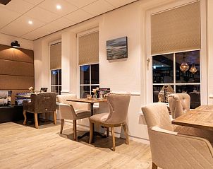 Elegante eetruimte met houten tafels in Hotel Restaurant Molenzicht, Nes, Ameland.