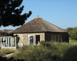 De Vijfhoek vakantiehuis met rieten dak in Nes, Ameland, omgeven door natuur.