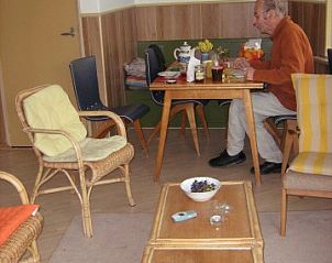Gezellige woonkamer van De Vijfhoek vakantiehuis in Nes, Ameland, met houten meubels.