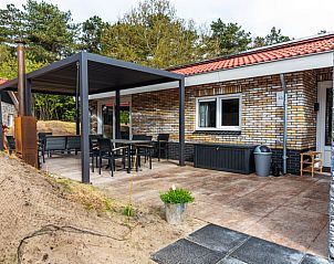 Veranda des Ferienhauses in Nes, Ameland, mit groem Sitzbereich und Blick auf die Natur.