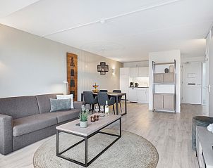 Gemtliche Sitzecke in Ameland State 2-Bett-Wohnung in Nes, Ameland mit Wein und Glsern auf dem Tisch.