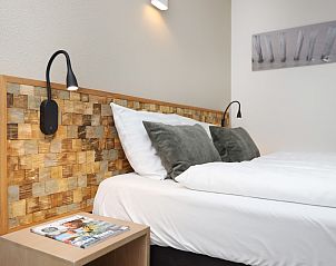 Gemtliches Schlafzimmer mit Holzdetails in Ameland Staatliche 2-Zimmer-Wohnung in Nes, Ameland.