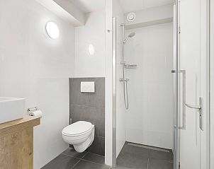 Gerumiges Badezimmer in Ameland State 2-Bett-Wohnung in Nes, Ameland mit Doppelwaschbecken und Badewanne.