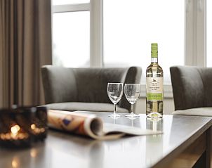 Stilvolle Sitzecke in der Ameland State Wohnung in Nes, Ameland, mit Wein und Glsern auf dem Tisch.
