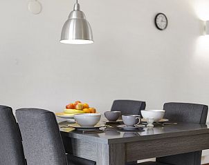 Esszimmer in Ameland State flat in Nes, Ameland, mit gedecktem Tisch und moderner Beleuchtung.