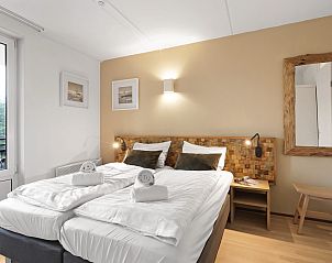 Slaapkamer met balkon in Ameland State appartement in Nes, Ameland voor een ontspannen verblijf.