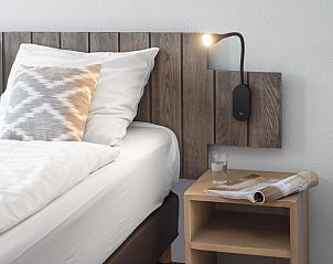 Nachttisch mit Zeitschrift und Glas Wasser im Schlafzimmer der Ameland State flat, Nes, Ameland.