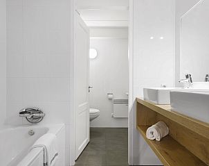 Luxurises Badezimmer mit Badewanne und Doppelwaschbecken in Ameland State flat, Nes, Ameland.