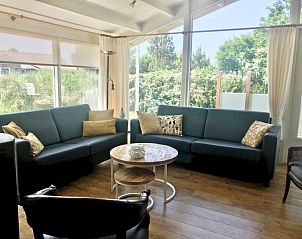 Ruime woonkamer met grote ramen in Campanula vakantiehuis, Ballum, Ameland, Waddeneilanden.