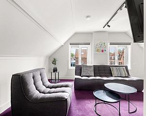 Lichte zitkamer in De Dorsvloer appartement, Domburg, Walcheren met moderne meubels en uitzicht op de omgeving.