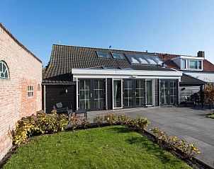 Ruime tuin van De Dorsvloer vakantiehuis in Domburg, Walcheren met terras en groene omgeving.