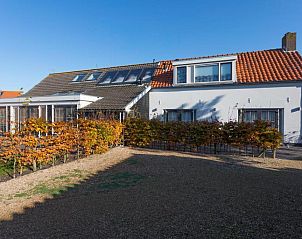 Zonnige tuin van De Dorsvloer, Domburg, Walcheren met comfortabele ligstoelen en zitruimte.