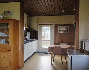 Gezellige keuken van vakantiehuis Zeerust op Schiermonnikoog, Waddeneilanden, met houten interieur en eethoek voor een ontspannen verblijf.