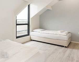 Slaapkamer met eenpersoonsbedden in Vitamaris appartement, ideaal voor kinderen op Schiermonnikoog.