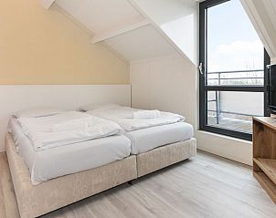 Comfortabele slaapkamer met tweepersoonsbed en uitzicht in Vitamaris appartement op Schiermonnikoog.